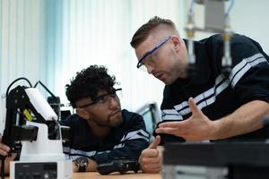 The robotic hand technology teacher is instructing new pupils on how to construct robotic hands for a variety of industrial applications. photo