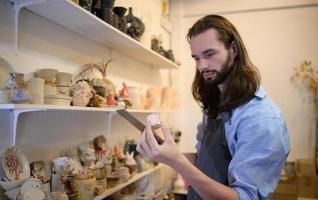 Businessman having a little ceramic business, Checking products in the store to prepare them for sale or to order more production. photo