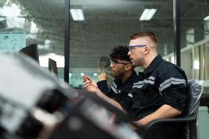 The robotic hand technology teacher is instructing new students on how to use electronic circuit boards and robotic hand commands for a variety of industrial applications. photo