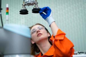 In an electronic parts facility, Female engineers In the plant, inspecting and testing robotic hands used in the production of electronic components. photo