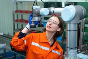 In an electronic parts facility, Female engineers In the plant, inspecting and testing robotic hands used in the production of electronic components. photo