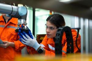 In an electronic parts facility, two female engineers In the plant, inspecting and testing robotic hands used in the production of electronic components. photo