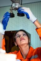 In an electronic parts facility, Female engineers In the plant, inspecting and testing robotic hands used in the production of electronic components. photo