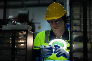 The technician must use bright lights and a magnifying glass to check the detail of the workpiece. the 3D printer's printout. photo