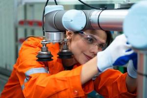 en un electrónico partes instalación, hembra ingenieros en el planta, inspeccionando y pruebas robótico manos usado en el producción de electrónico componentes foto