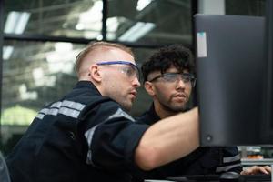 The robotic hand technology teacher is instructing new students on how to use electronic circuit boards and robotic hand commands for a variety of industrial applications. photo