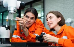 In an electronic parts facility, two female engineers In the plant, inspecting and testing robotic hands used in the production of electronic components. photo