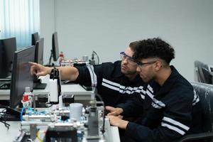 el robótico mano tecnología profesor es instruyendo nuevo estudiantes en cómo a utilizar electrónico circuito tableros y robótico mano comandos para un variedad de industrial aplicaciones foto