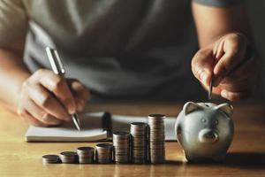 saving money with hand putting coins in piggy bank concept financial photo