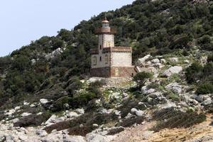 A lighthouse is a navigational landmark that is used to identify coasts and locate ships. photo