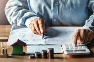 businessman working on desk office with using a calculator to calculate finance accounting concept photo