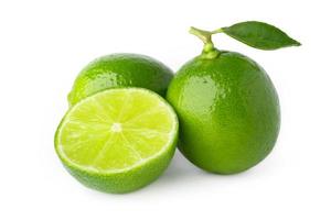 two lime with half and green leaf isolate on white background photo