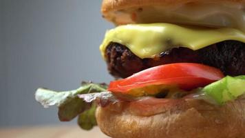 frischer leckerer hausgemachter hamburger mit frischem gemüse, salat, tomate, käse auf einem schneidebrett. Freiraum für Text video