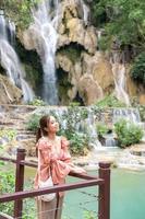 Asian woman standing on the wooden walkway in the Kuang Si Waterfall  Lung Prabang, Laos photo