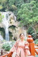 Asian woman standing on the wooden walkway in the Kuang Si Waterfall  Lung Prabang, Laos photo