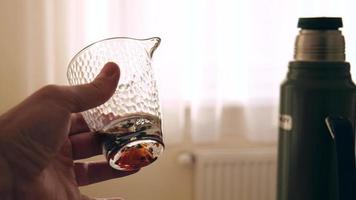 a man holds a glass bowl in his hand for the Chinese tea ceremony video