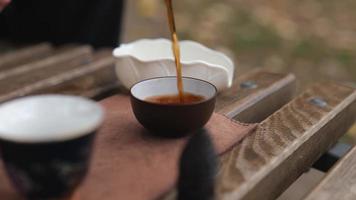 dark pu-erh is poured into bowls for tea. Chinese tea ceremony video