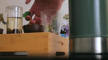 a tea lover pours brewed white tea from a teapot into a special tea glassware video