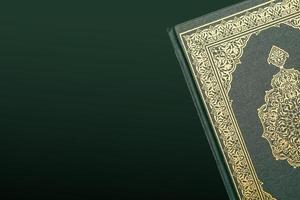 el santo Alabama Corán con escrito Arábica caligrafía sentido de Alabama Corán y rosario rosario o tasbih en oscuro verde negro antecedentes con Copiar espacio. foto