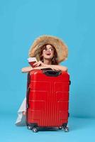 mujer con rojo maleta sentado en el piso pasaporte y avión Entradas estilo de vida foto