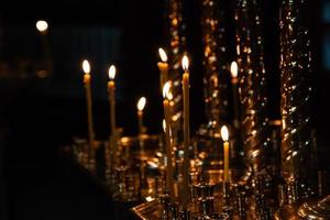 Church candles burn in a candlestick against the backdrop of icons photo