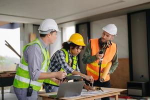 Engineers are discussing data working and laptop or tablet with architectural project at new construction site on big project. photo