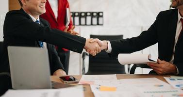 business people shaking hands during a meeting in modern office photo
