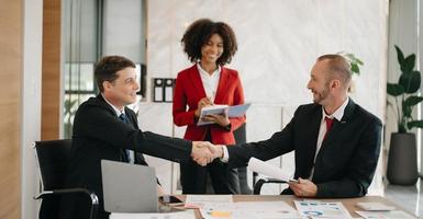 business people shaking hands during a meeting in modern office photo