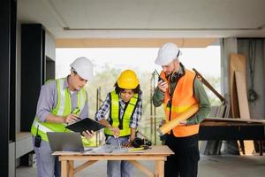 Engineers are discussing data working and laptop or tablet with architectural project at new construction site on big project. photo