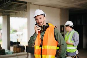 Contractor and architect looking at plan, tablet, laptop and talking about working on big project. Building in construction process interior. team work photo