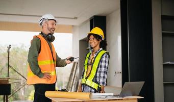 Architect caucasian man and woman working with colleagues mixed race in the construction site. Architecture engineering on big project. Building in construction process interior. photo