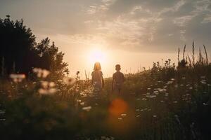 Boy and girl walking at blooming field in sunset. photo