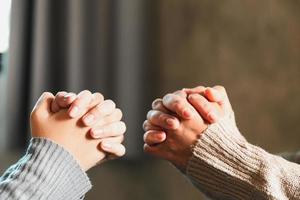 Small group of asian people praying worship believe. Teams of friends worship together before studying Holy bible. family praying together in church. Small group learning with prayer concept. photo