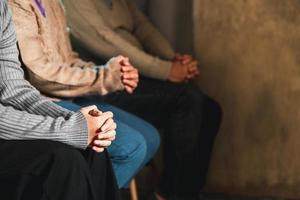 Small group of asian people praying worship believe. Teams of friends worship together before studying Holy bible. family praying together in church. Small group learning with prayer concept. photo