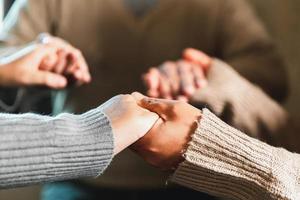 Small group of asian people praying worship believe. Teams of friends worship together before studying Holy bible. family praying together in church. Small group learning with prayer concept. photo