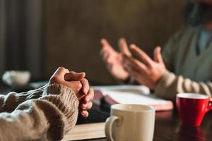 Small group of asian people praying worship believe. Teams of friends worship together before studying Holy bible. family praying together in church. Small group learning with prayer concept. photo