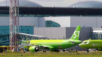 novosibirsk, ruso federación julio 15, 2022 - pasajero avión de s7 aerolíneas llegada a el aeropuerto. pasajeros consiguiendo apagado el avión en el escaleras. turismo y viaje concepto video