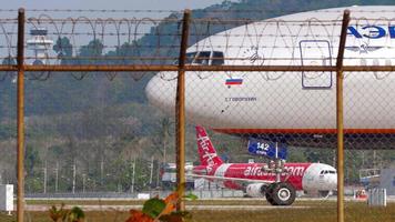 phuket, Tailândia janeiro 28, 2023 - corpo largo avião boeing 777 do aeroflot em a taxiway ou pista, phuket aeroporto. Visão do a cockpit. avião em a aeródromo. trator puxar airásia, fundo video