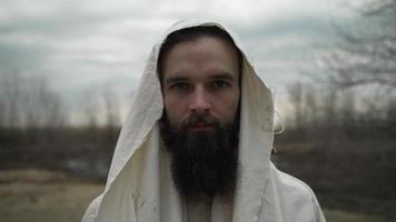 homme avec barbe habillé comme Jésus Christ dans blanc peignoir video