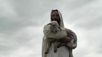 un amoroso pastor participación un bebé oveja, Cordero en su brazos video