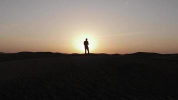 silhouet van Mens in zonsondergang Aan zand duinen in woestijn video