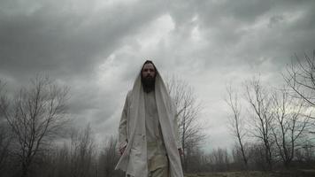 homme dans blanc peignoir habillé comme Jésus en marchant video
