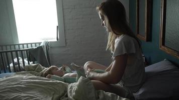 madre vendaje su bebé niña en cama video