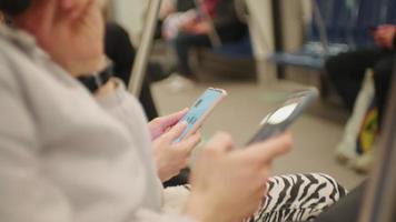 coppie mani vicino su utilizzando smartphone su il metropolitana. video