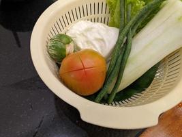 Close up photo of salad on the white basket, tomato, eggplant and cabbage. The photo is suitable to use for vegan food background, poster and food content.