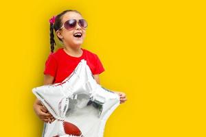 Little girl with balloons on a orange background photo