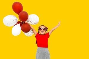 pequeño niña con globos en un naranja antecedentes foto