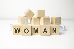 wooden cube block with woman business word on table background. photo