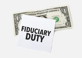 1 dollar bill and white notepad sheet on the white background. Text fiduciary duty photo