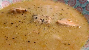 The surface of a hot fish soup with pieces of fish in a bowl. video